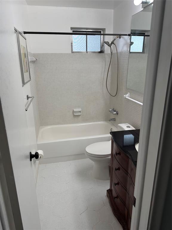 1821 Northeast 62nd Street, Unit 432 Fort Lauderdale, FL 33308 - Photo 15 of 29 a bathroom with a granite countertop bathtub shower sink vanity and toilet
