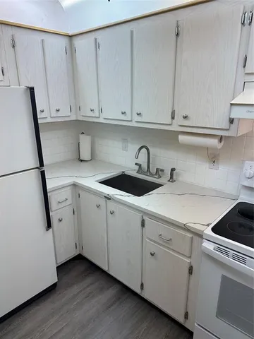 a kitchen with white cabinets and white appliances