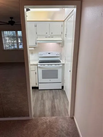 a kitchen with white cabinets and a stove