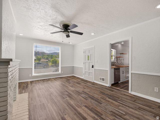 74 South 300 East Springville, UT 84663 - Photo 4 of 48 Spacious living area featuring wood-finish flooring, a white brick fireplace, and a ceiling fan