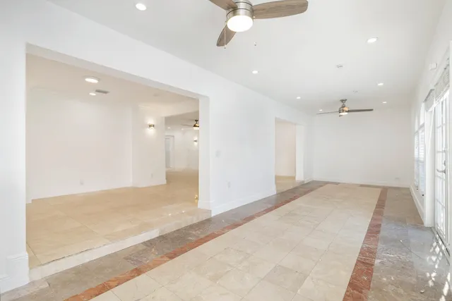 en empty room with windows and fan