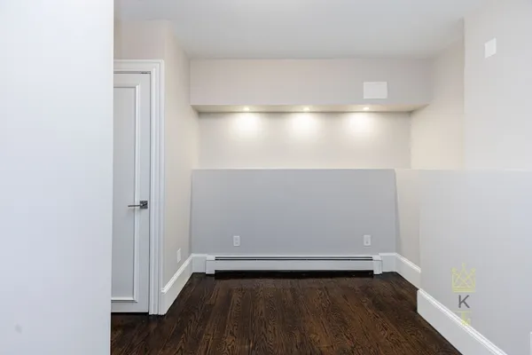 a view of an empty room with wooden floor