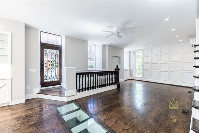 a view of an empty room with a window and wooden floor