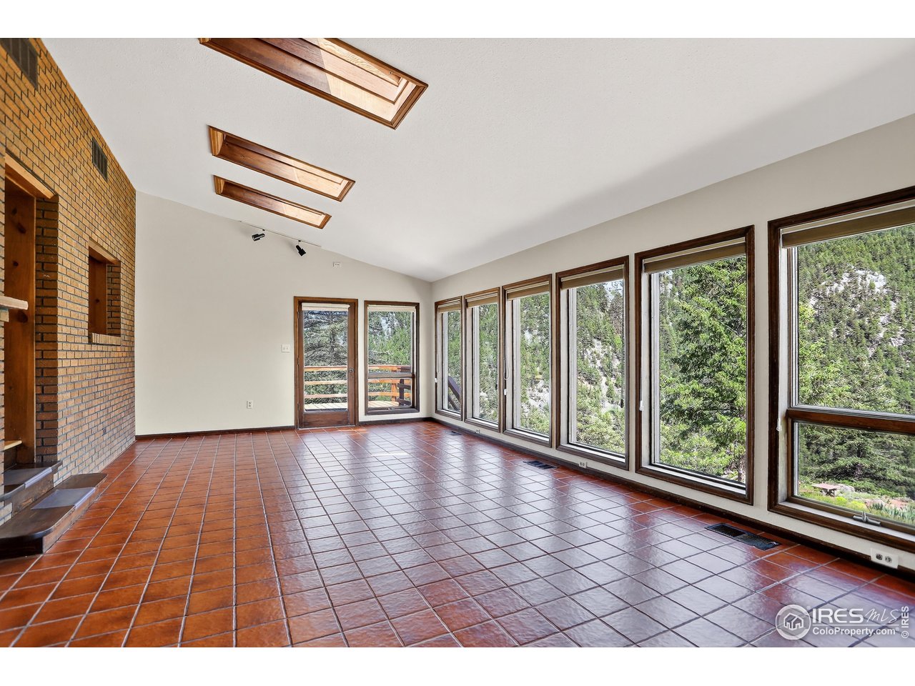 192 Nugget Hill Road Jamestown, CO 80455 - Photo 8 of 25 a view of an empty room with wooden floor and a window