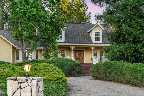 a front view of a house with a yard and potted plants
