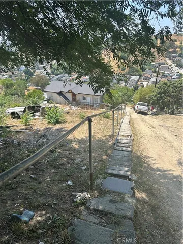 a view of a yard with wooden fence