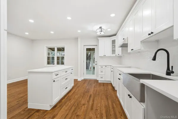 a kitchen with a dining table chairs and wooden floor