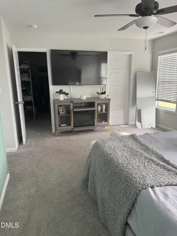 a spacious bedroom with a bed and a flat screen tv