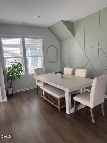 a living room with furniture a potted plant and a wooden floor
