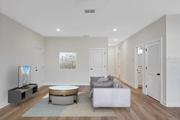 a living room with furniture and a wooden floor