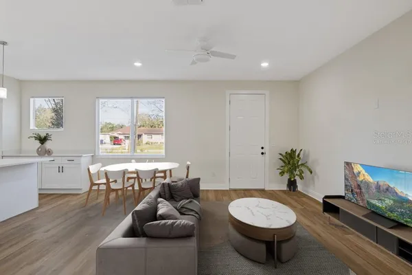 a living room with furniture a piano and a flat screen tv