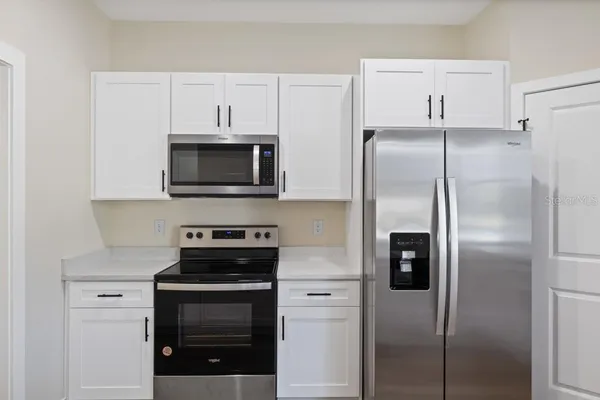 a kitchen with a refrigerator stove and microwave