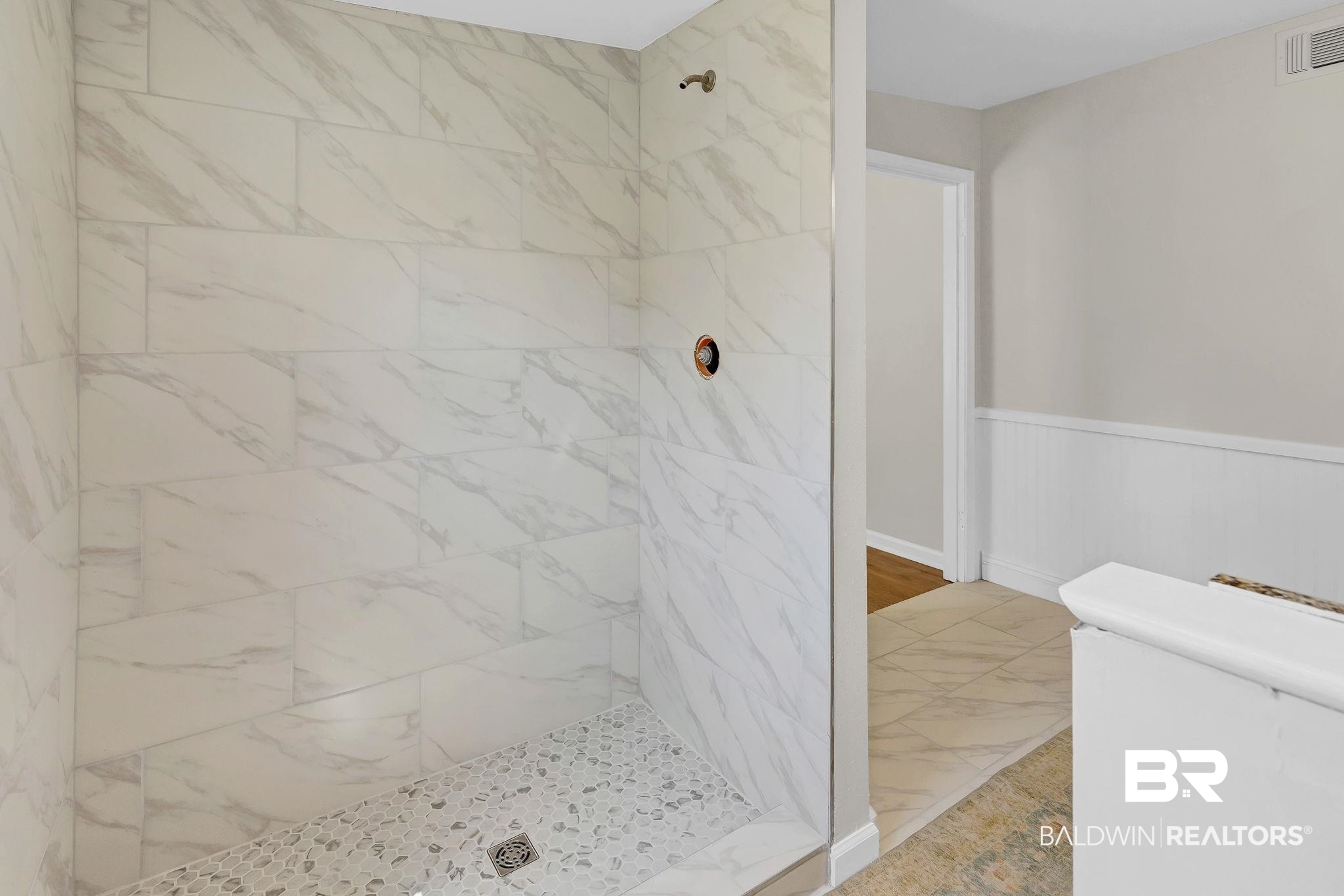 11964 Stroh Road Daphne, AL 36527 - Photo 41 of 58 Bathroom with tiled shower, wainscoting, and visible vents