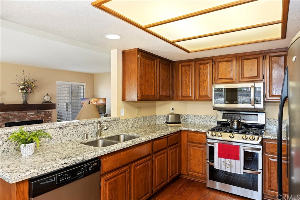 3534 Broken Feather Drive Norco, CA 92860 - Photo 11 of 33 a kitchen with stainless steel appliances granite countertop a sink stove and cabinets