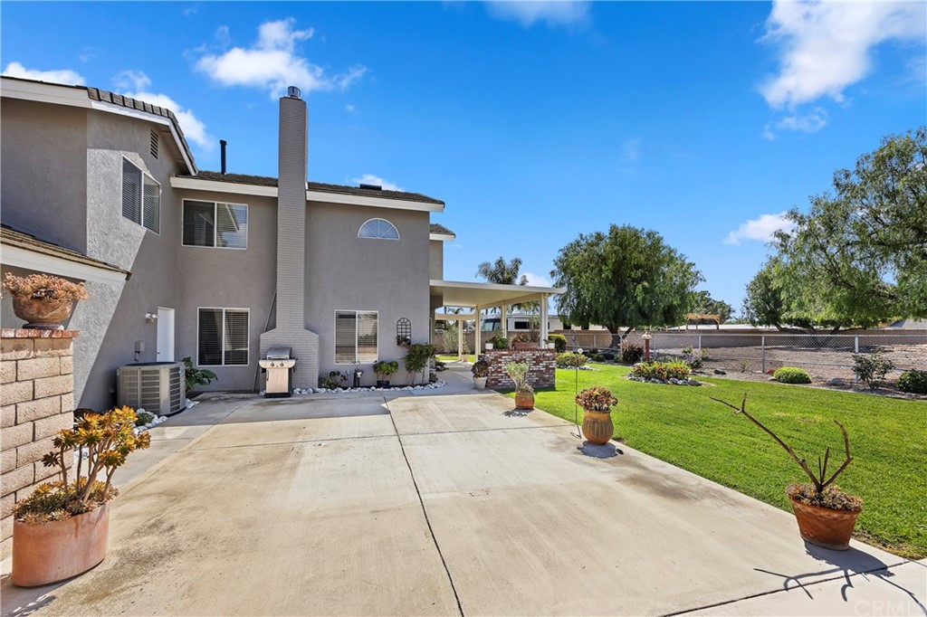 3534 Broken Feather Drive Norco, CA 92860 - Photo 30 of 33 a view of a patio with a dining table and chairs with a fire pit and large trees