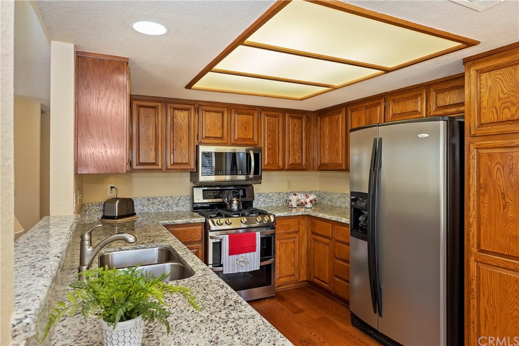 3534 Broken Feather Drive Norco, CA 92860 - Photo 10 of 33 a kitchen with stainless steel appliances granite countertop a refrigerator a stove top oven a sink and dishwasher