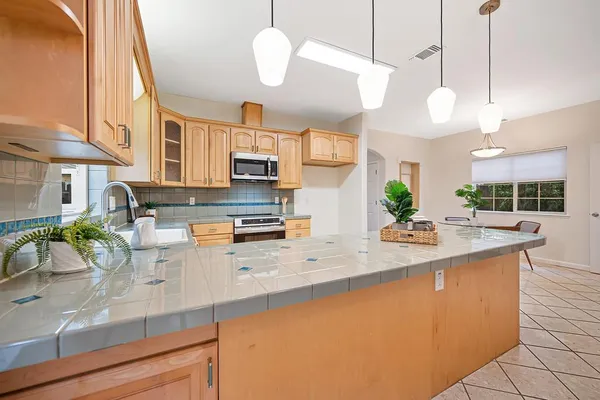a kitchen with stainless steel appliances granite countertop a sink a stove and refrigerator