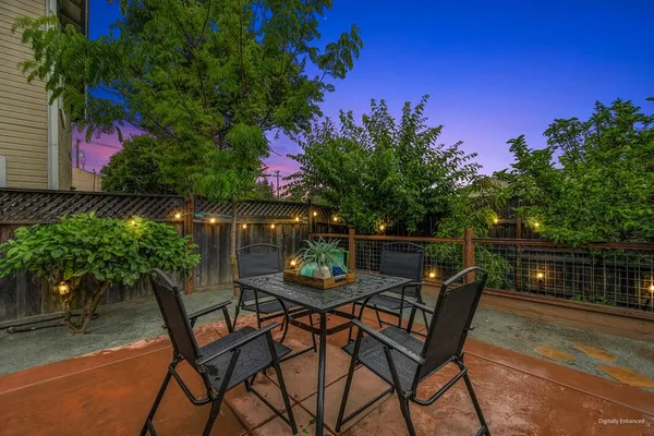 a view of a patio with table and chairs and potted plants with wooden floor and wall