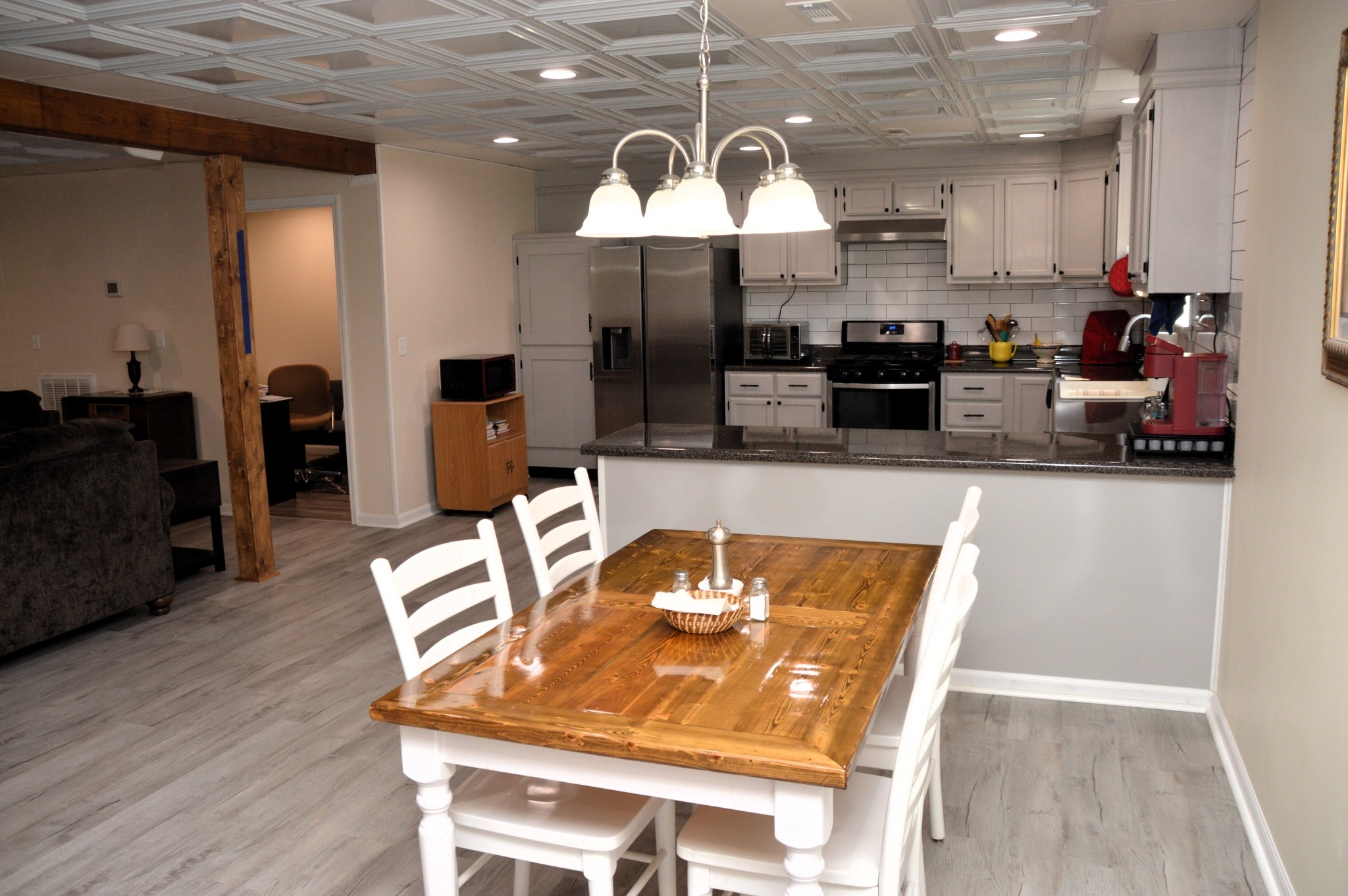351 Hurricane Creek Road Linden, TN 37096 - Photo 14 of 41 a kitchen with stainless steel appliances granite countertop a stove a sink a refrigerator and a dining table with wooden floor