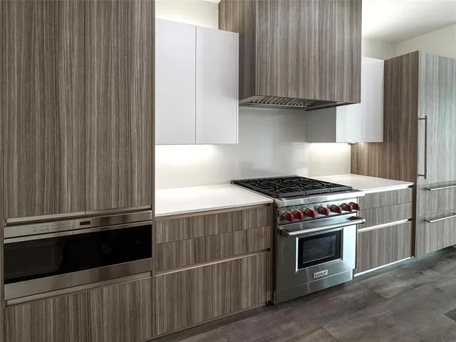 a kitchen with granite countertop a stove and a refrigerator