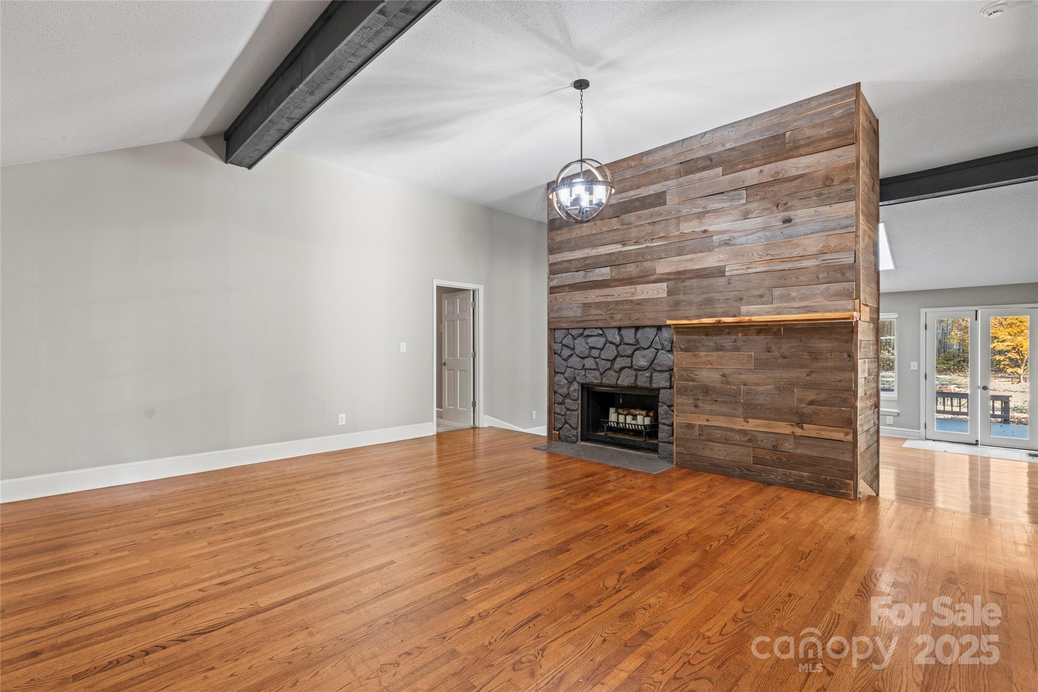 3616 Spokeshave Lane Matthews, NC 28105 - Photo 8 of 45 a view of an empty room with wooden floor fireplace and a window