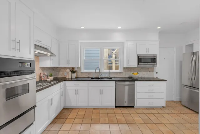 a kitchen with a sink cabinets and stainless steel appliances