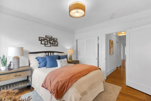 a bedroom with a bed and painting on the wall