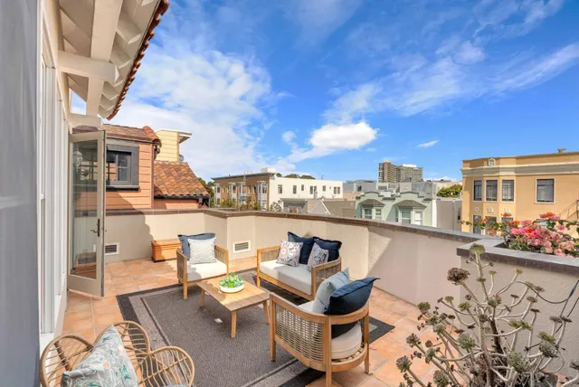 a view of a balcony with chairs and potted plants