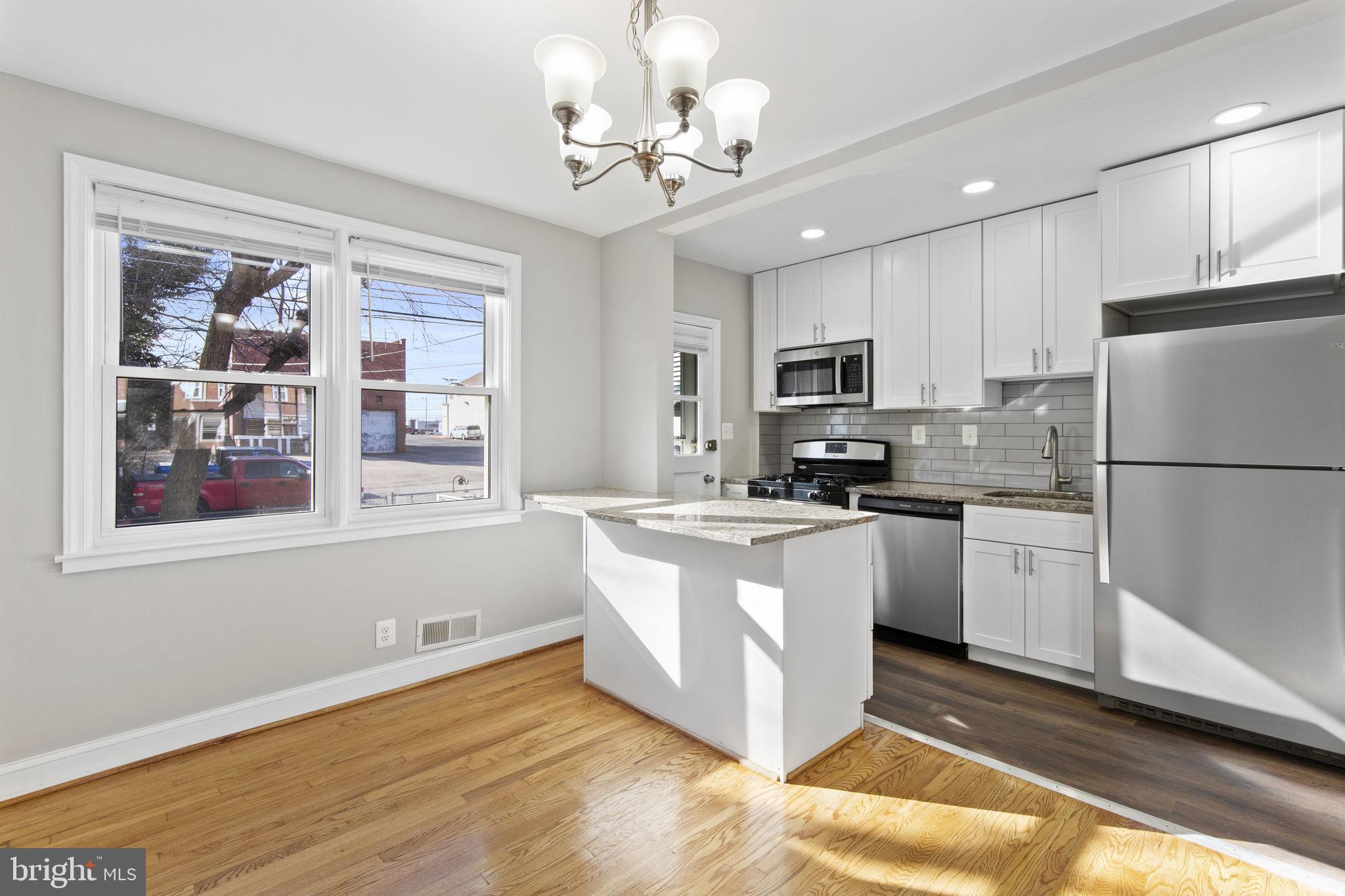 7571 Westfield Road Dundalk, MD 21222 - Photo 4 of 21 a kitchen with granite countertop a refrigerator stove top oven and cabinets