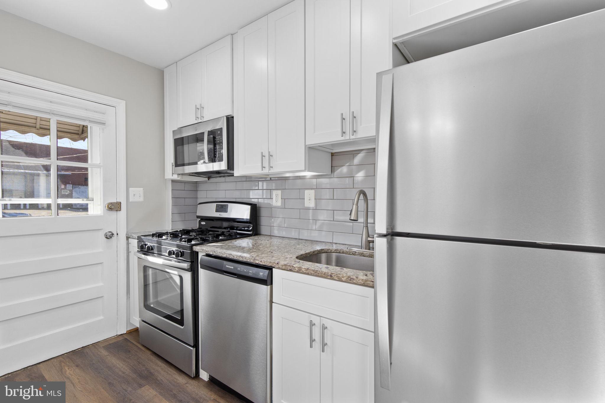 7571 Westfield Road Dundalk, MD 21222 - Photo 6 of 21 a kitchen with cabinets appliances and a window