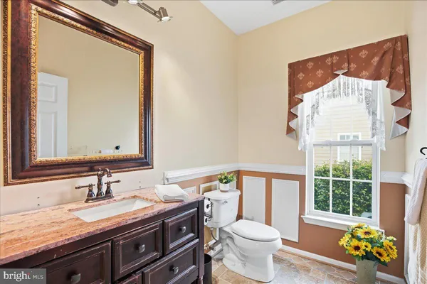 a kitchen with stainless steel appliances granite countertop a refrigerator a oven a sink dishwasher and a dining table with wooden floor