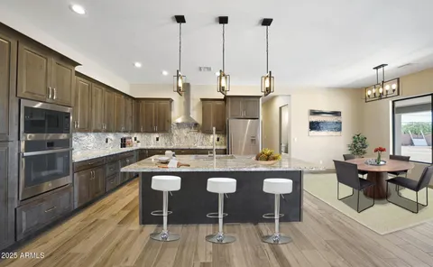 a large kitchen with kitchen island a dining table chairs and a wooden floor
