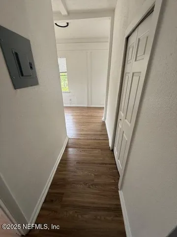a view of a hallway with wooden floor and staircase