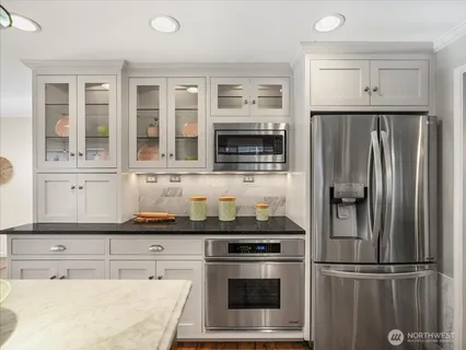 a kitchen with stainless steel appliances a refrigerator sink and microwave