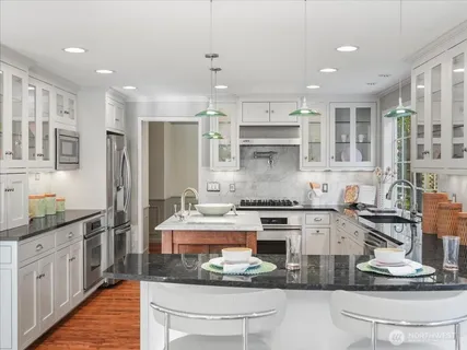 a kitchen with kitchen island granite countertop counter top space appliances and cabinets