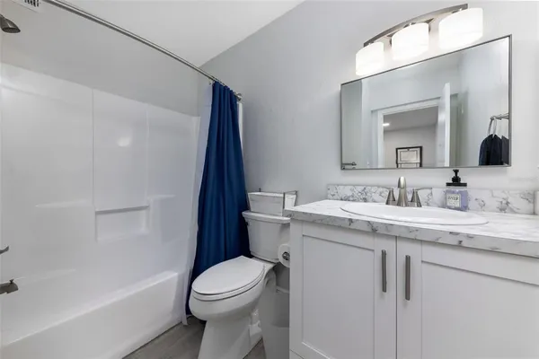 a bathroom with a granite countertop sink toilet and shower