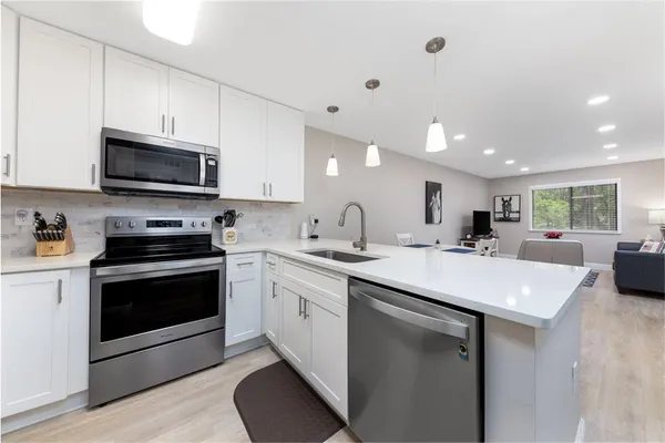 a kitchen with stainless steel appliances granite countertop a sink and a stove