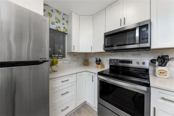 a kitchen with stainless steel appliances a stove a microwave and cabinets