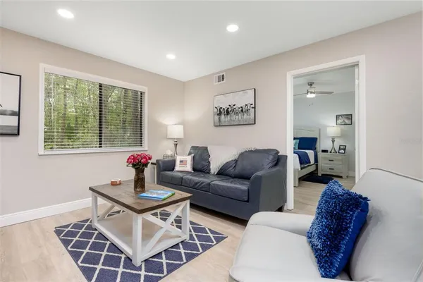 a living room with furniture a rug and a window