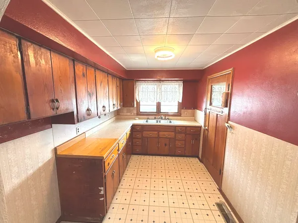 a large kitchen with stainless steel appliances granite countertop a refrigerator a sink dishwasher and wooden cabinets with wooden floor