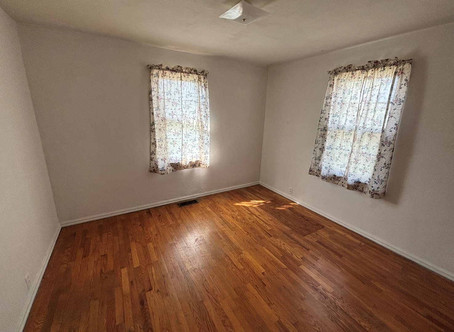 107 Dewolf Street Odin, IL 62870 - Photo 6 of 10 an empty room with wooden floor and windows