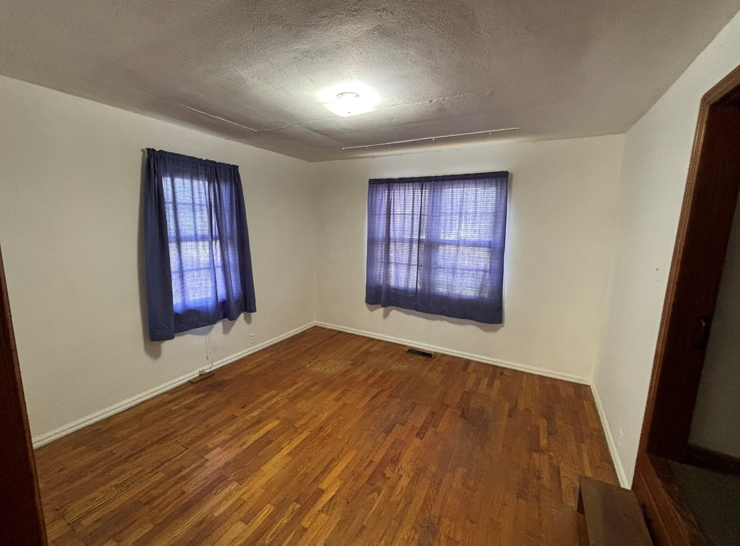 107 Dewolf Street Odin, IL 62870 - Photo 7 of 10 an empty room with wooden floor and windows
