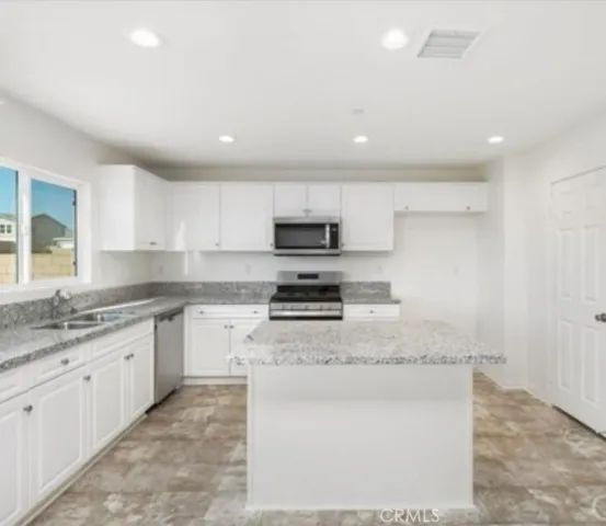 a kitchen with stainless steel appliances granite countertop a sink stove and microwave