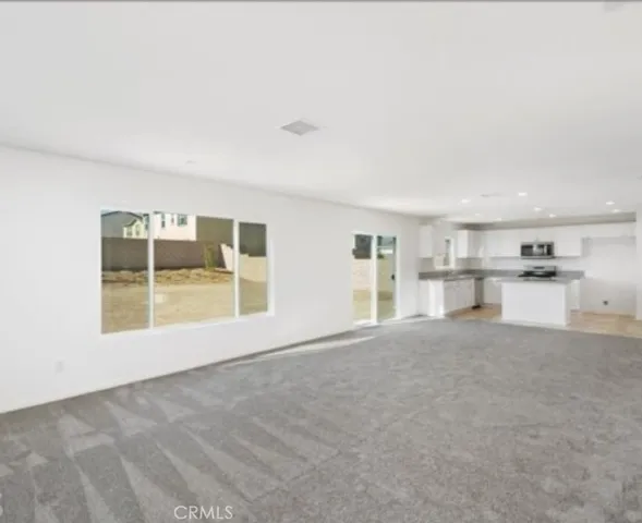 a view of empty room with a kitchen