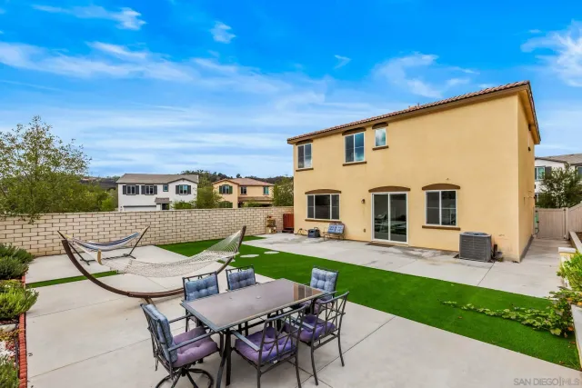 a backyard of a house with table and chairs