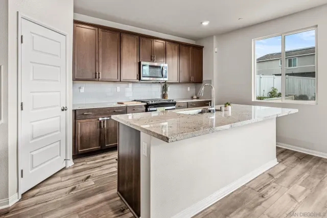 a kitchen with stainless steel appliances granite countertop a sink stove and cabinets
