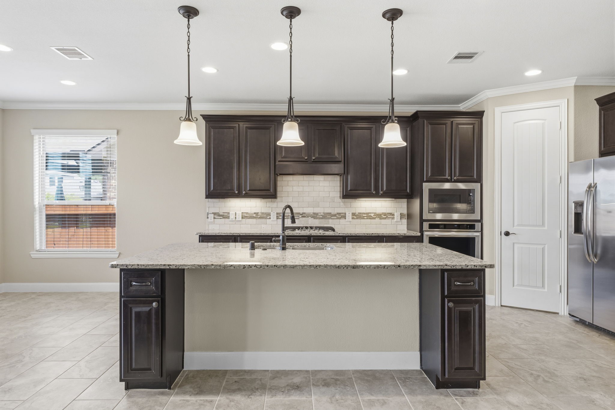 25210 Gaddis Oaks Drive Spring, TX 77389 - Photo 12 of 50 a kitchen with stainless steel appliances granite countertop a sink a stove and a refrigerator