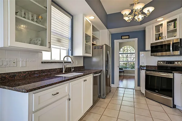 a kitchen with stainless steel appliances granite countertop a stove sink and microwave