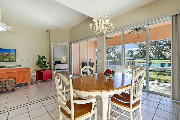 a dining room with furniture a chandelier and window