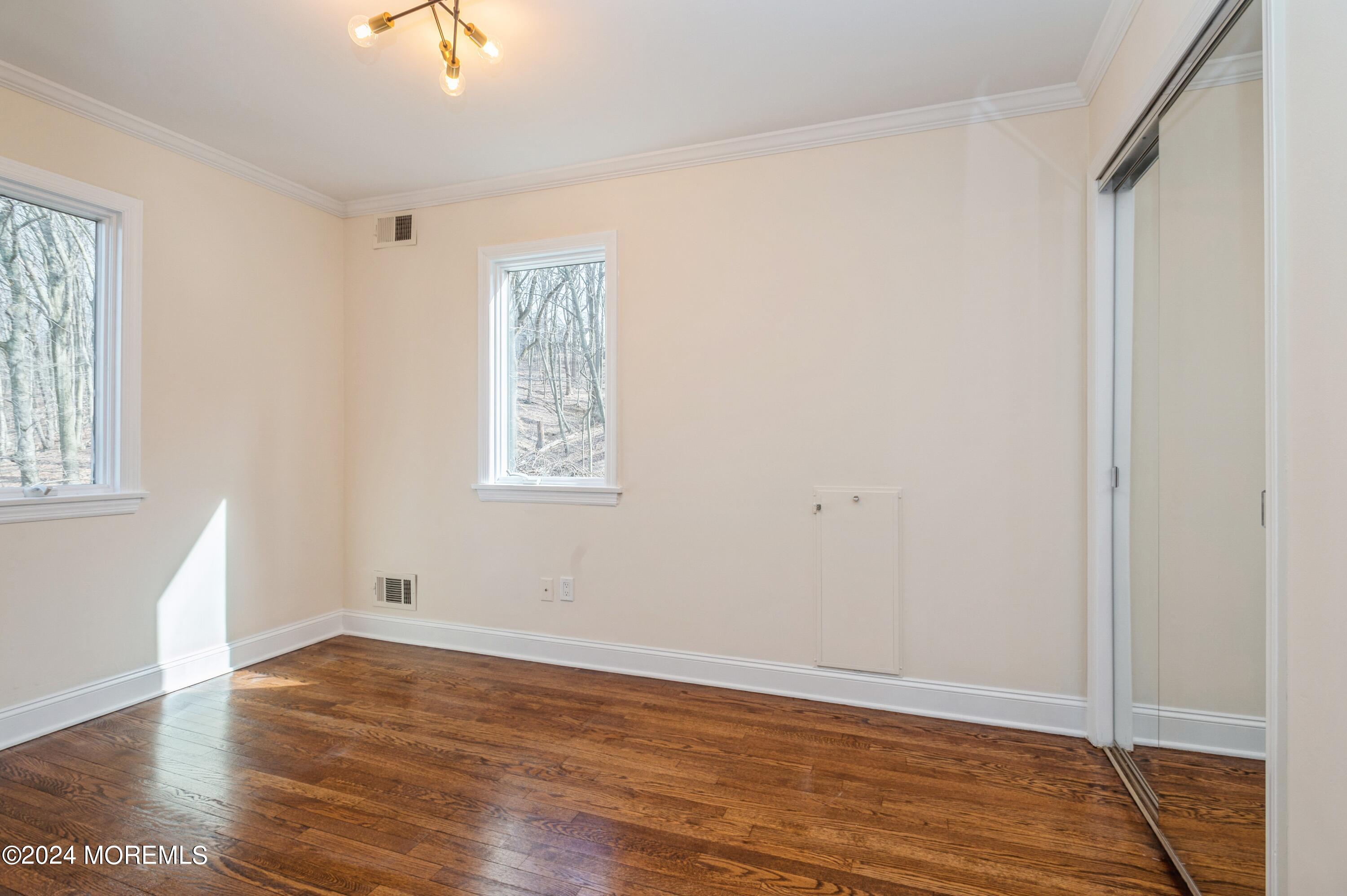 26 Van Brackle Road Holmdel, NJ 07733 - Photo 12 of 36 a view of an empty room with wooden floor and a window
